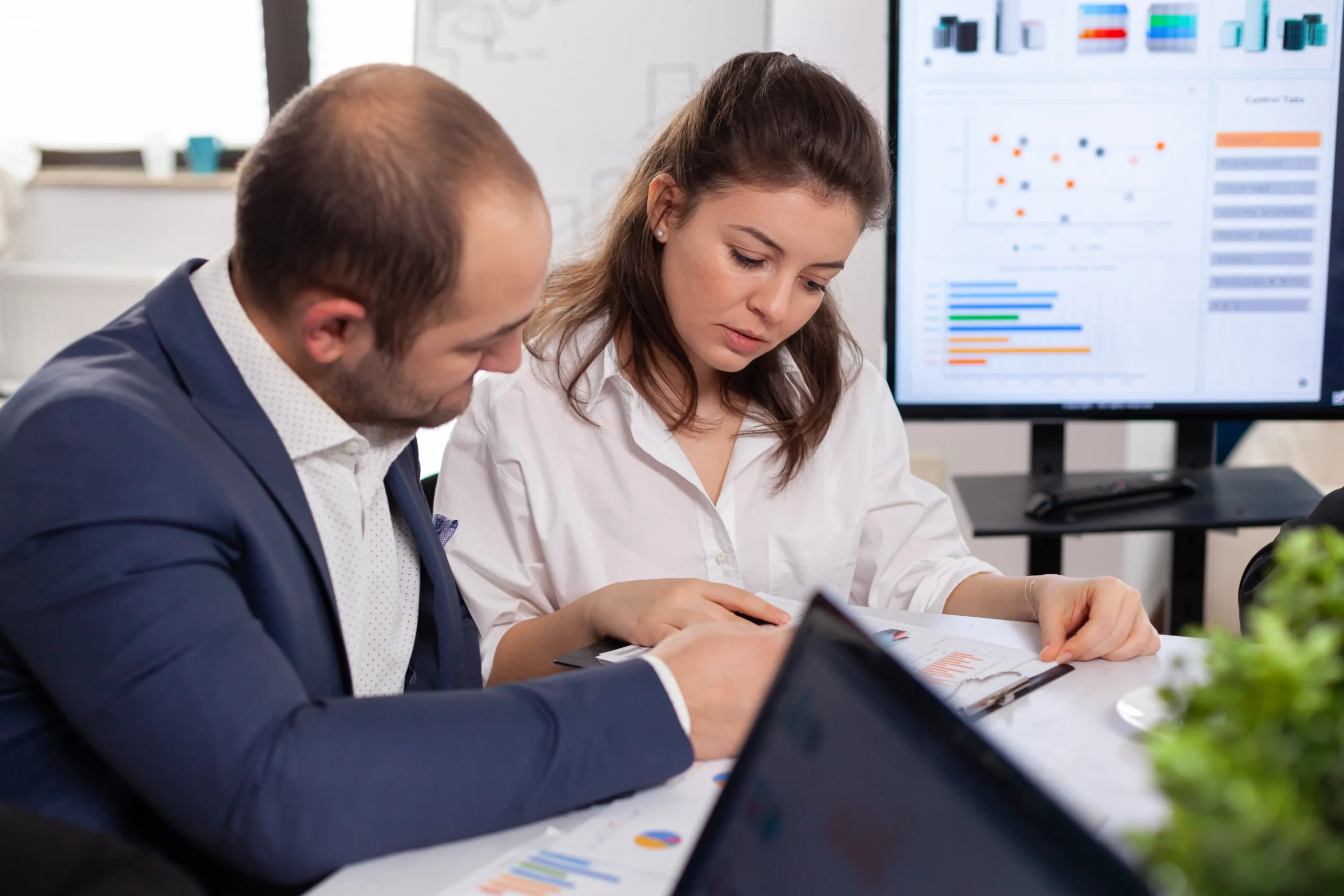 colleagues startup business discussing looking documents company board brainstorming conference room checking graphs charts scaled 1